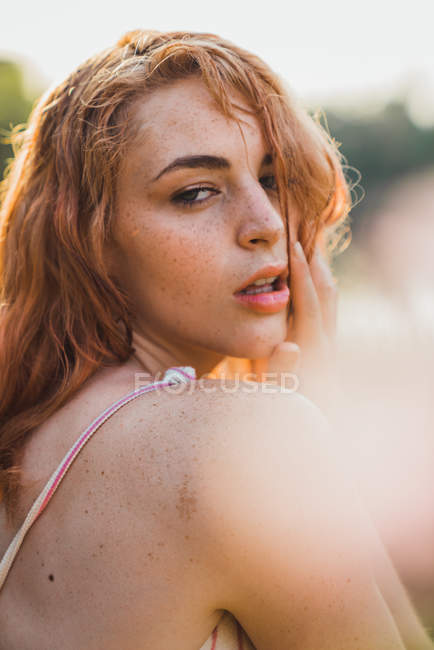 Retrato de mujer sensual pecosa joven en la luz del sol - foto de stock