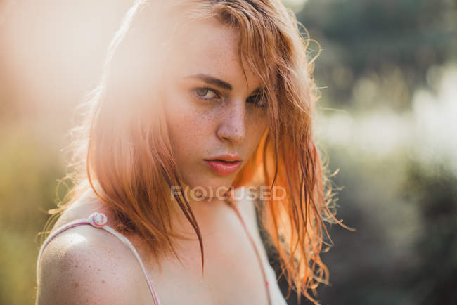 Portrait of Young freckled serious woman in sunlight — Stock Photo