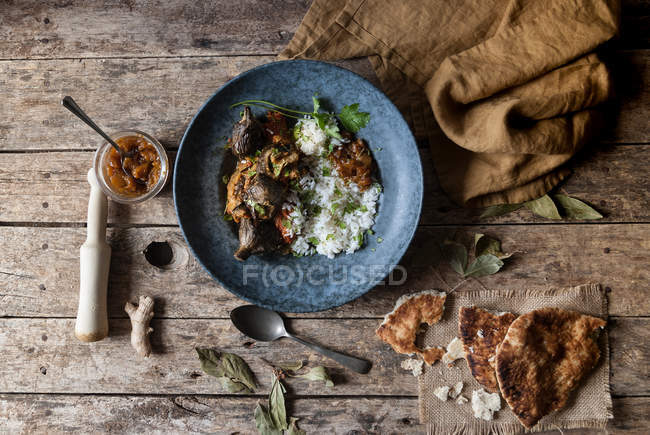 Roasted eggplants and rice with spices in plate on rustic wooden table — Stock Photo