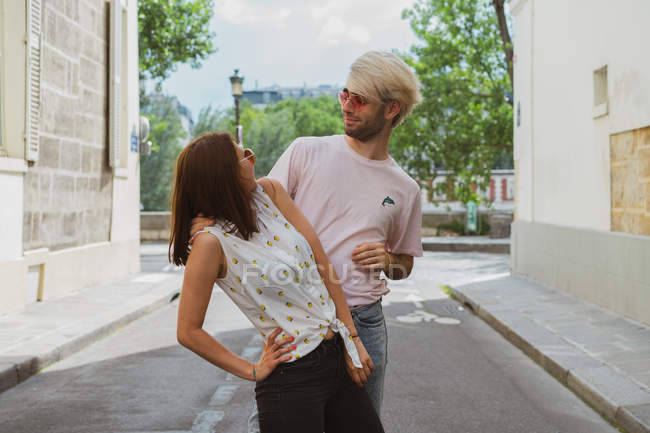 Hommes et femmes amis en lunettes de soleil posant dans la rue — Photo de stock