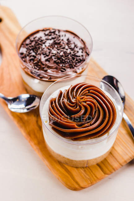 Close-up of chocolate dessert in cups on wooden board — Stock Photo