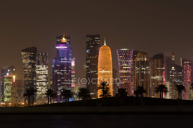 Hermosa vista de los rascacielos iluminados de la metrópolis por la noche.. - foto de stock