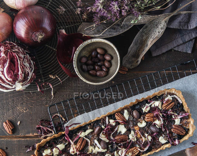 Radicchio pie with nuts and Gorgonzola on brown wooden table with ingredients — Stock Photo