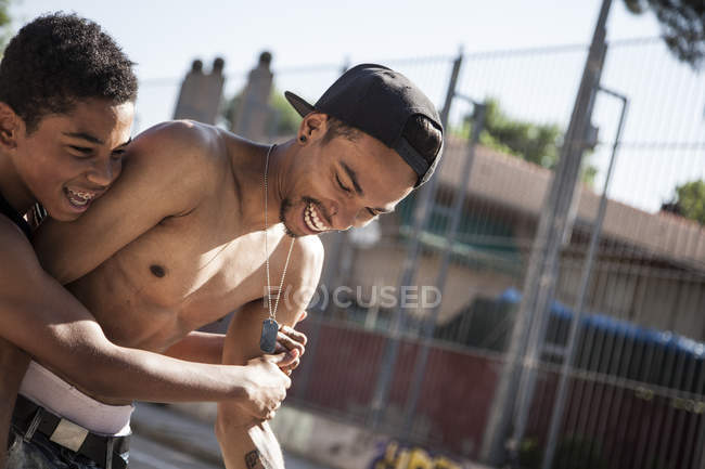 Giocoso afro giovani fratelli divertirsi sul campo da basket all'aperto — Foto stock