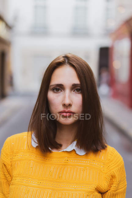 Porträt einer ernsthaften jungen Frau, die auf der Straße in die Kamera blickt — Stockfoto