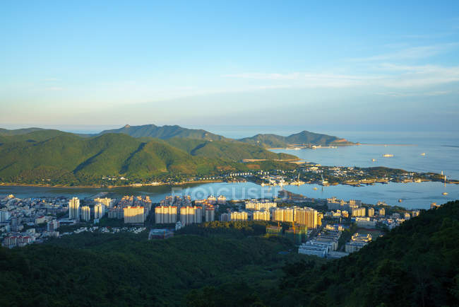 Stadtpanorama an grüner Küste und Seehafen mit Bergen unter blauem Himmel, Phönixpark, Sanya, China — Stockfoto