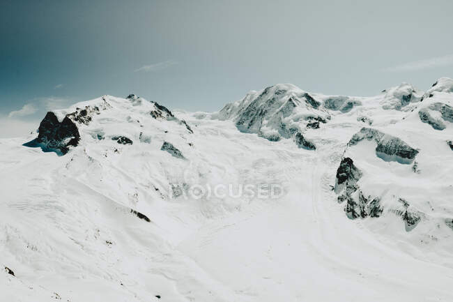 Desde arriba vista a las montañas blancas nevadas en el día de invierno. - foto de stock