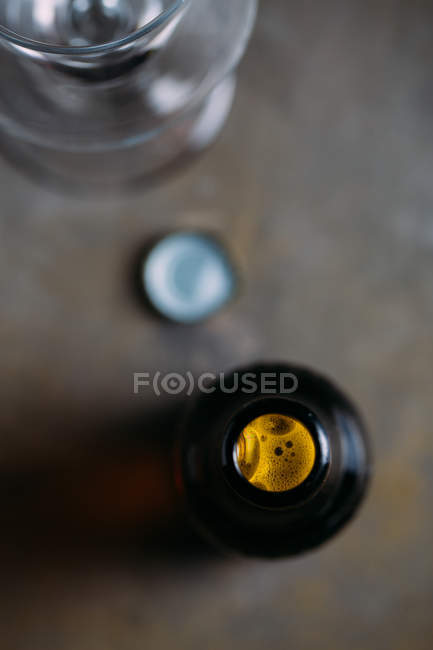 Крупним планом відкрита пляшка пива на сірому фоні — стокове фото
