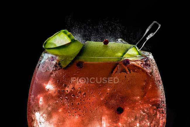 Closeup of bubbly red gin tonic with cucumber and pepper — Stock Photo