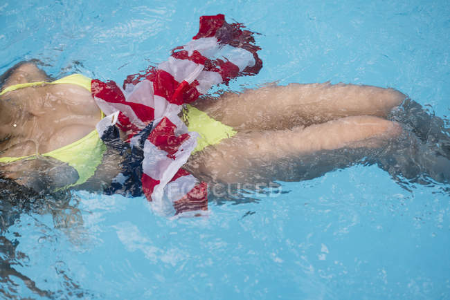 Frau schwimmt in Pool mit amerikanischer Flagge — Stockfoto