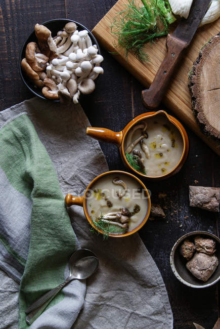 Подається в мисках смачний грибний крем на сільському дерев'яному столі з інгредієнтами — стокове фото