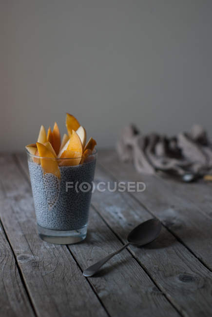 Delicioso pudín de chía con mango en vidrio sobre mesa de madera - foto de stock