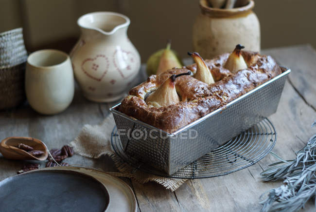 Свіжоспечений смачний грушевий пиріг у випічці на дерев'яному столі — стокове фото