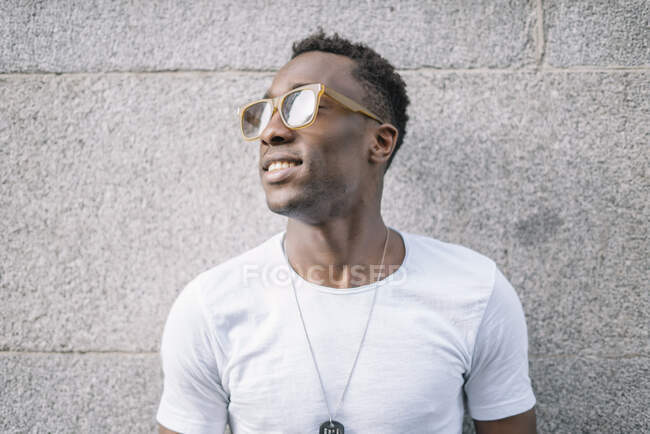 Uomo africano che indossa camicia bianca e occhiali da sole in posa. — Foto stock