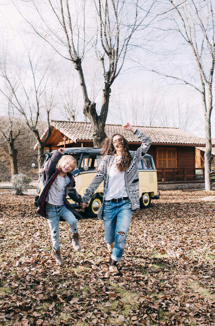 Ludique blond fille et jeune femme avoir du plaisir en face de vieux van dans la campagne — Photo de stock