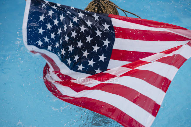 Frau steht mit amerikanischer Flagge im Pool — Stockfoto