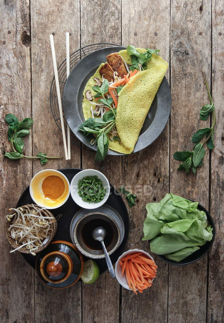 Vietnamesischer herzhafter Pfannkuchen mit Gemüse und Zutaten auf Holztisch — Stockfoto