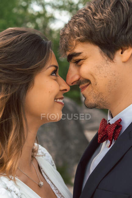 Crop vista laterale di allegro tenero uomo e donna che si toccano con il naso e si guardano con amore nel giorno del matrimonio — Foto stock