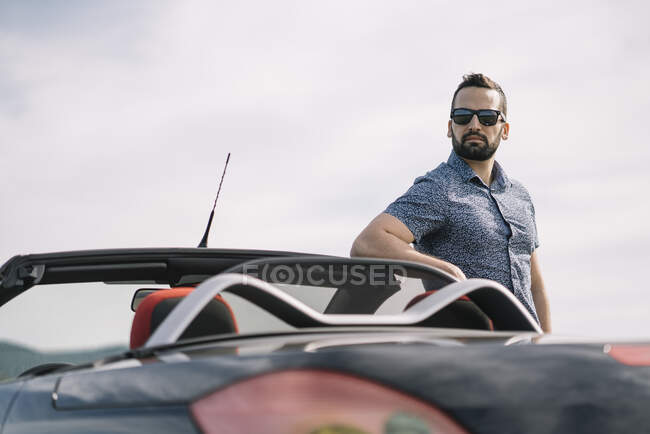Homme attrayant posant en voiture convertible. — Photo de stock