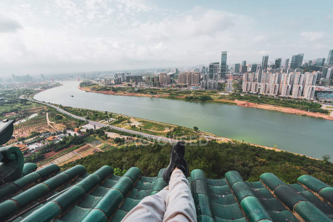 Ноги туриста на крыше с городским пейзажем на заднем плане, Наньнин, Китай — стоковое фото