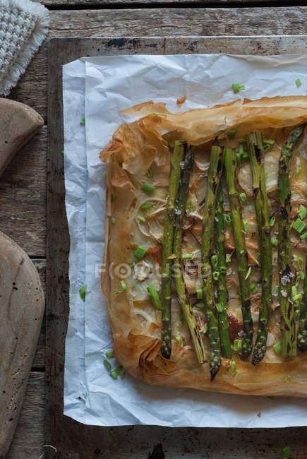 Baked asparagus pie on wooden surface — Stock Photo