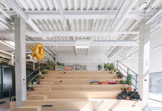 Интерьер современного офиса с деревянными ступеньками и местом для отдыха и сидений при дневном свете — стоковое фото