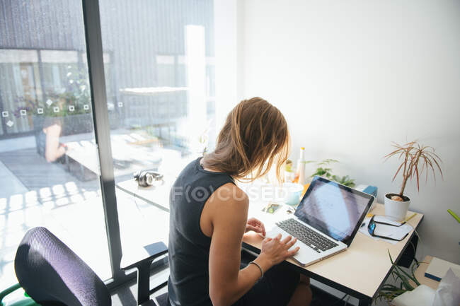 Frau arbeitet im sonnigen modernen Büro — Stockfoto