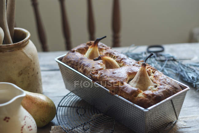 Freshly baked delicious pear pie in baking dish on wooden table — Stock Photo