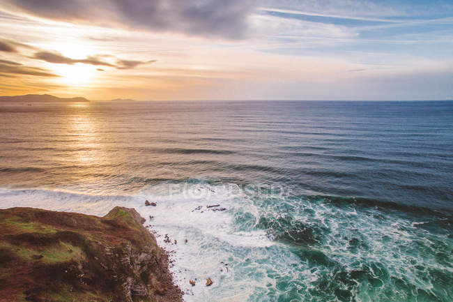 Onde dell'oceano che rotolano sulla costa al tramonto — Foto stock