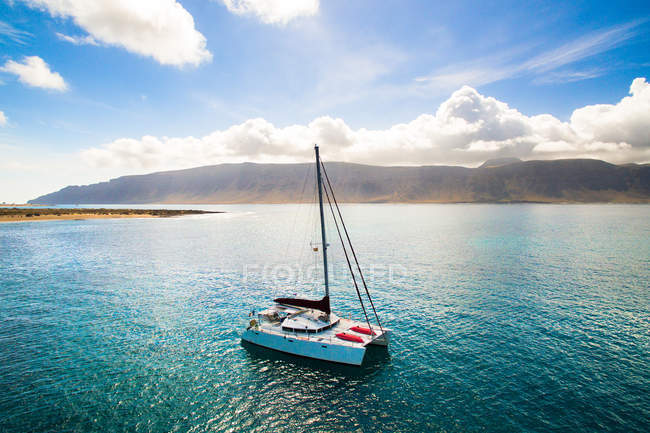 Small yacht navigating in picturesque bay, La Graciosa, Canary Islands — Stock Photo