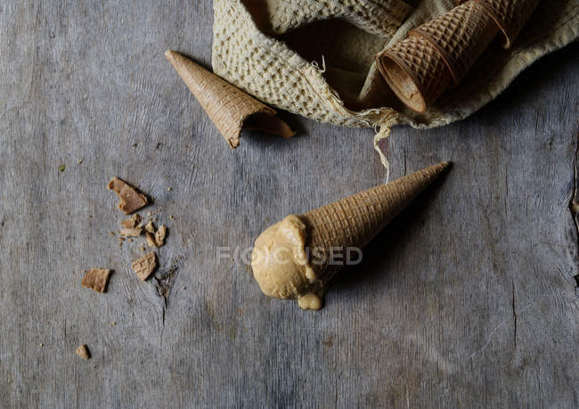 Tasty ice cream in crunchy sugar cone on grey wooden table — Stock Photo