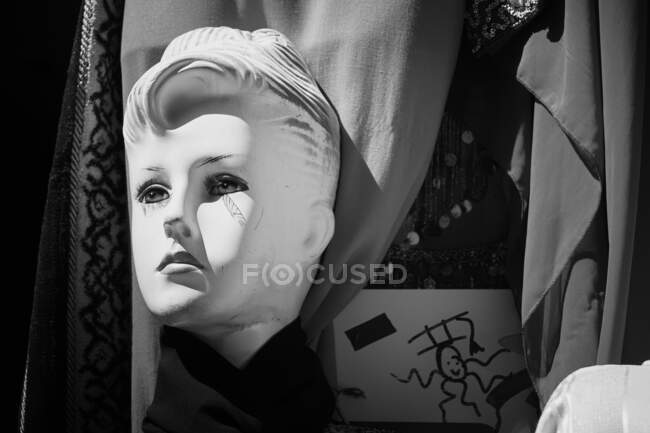 Escultura de alabastro branco da cabeça da mulher colocada perto da cortina em cores preto e branco — Fotografia de Stock