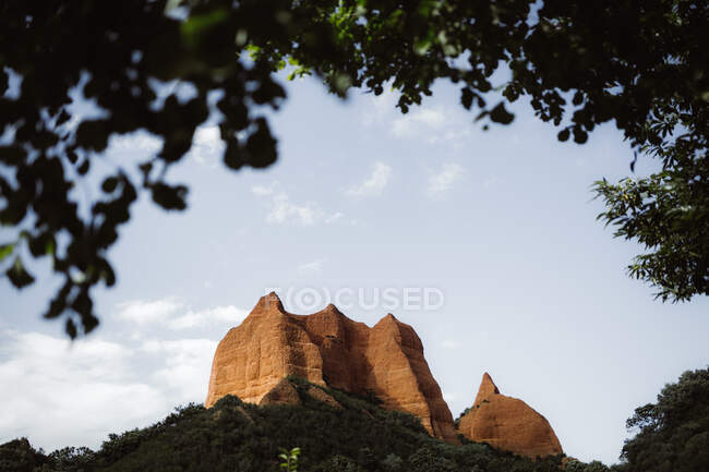 Каменистая гора, стоящая между зеленым лесом на фоне неба в Кантоне, Испания — стоковое фото