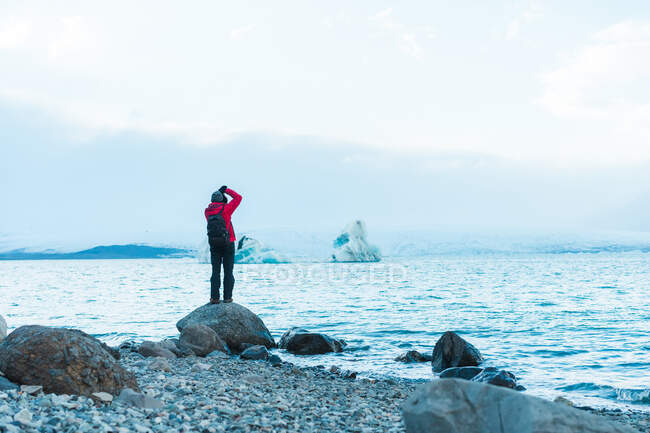 Uomo in abiti caldi scattare foto del lago — Foto stock
