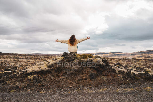 Donna seduta su sfondo sassoso pittoresco — Foto stock