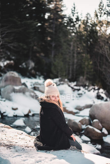 Усміхнена жінка на річці взимку — стокове фото