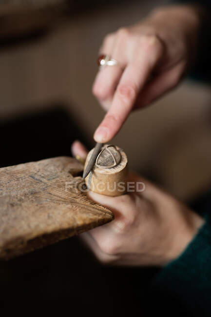 Ritaglio mani ravvicinate di donna intaglio dettaglio in legno con coltello alla scrivania — Foto stock