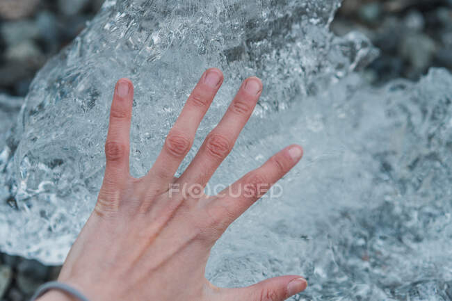 Person holding crop hand above ice piece in Skaftafell, Iceland and Vatnajokull — Stock Photo