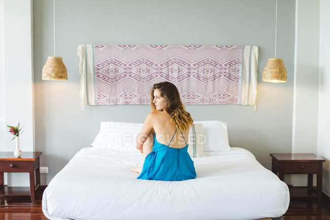 Frau sitzt auf Bett — Stockfoto