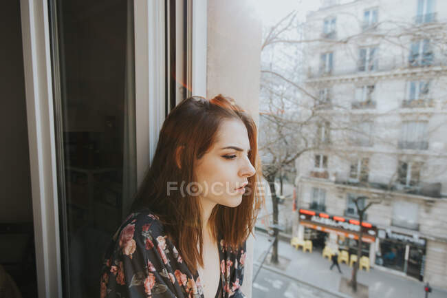 Jeune femme posant à la fenêtre — Photo de stock