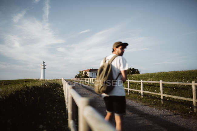 Людина на пішохідній доріжці біля маяка — стокове фото