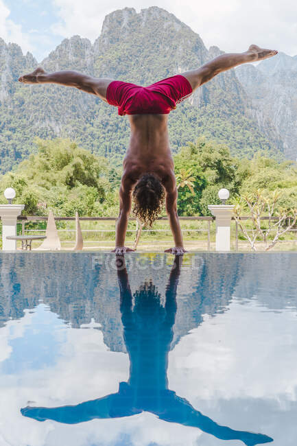 Homme debout à l'envers sur la piscine — Photo de stock