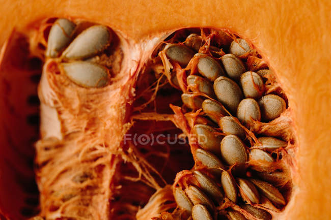 Moitié fraîche et juteuse de citrouille orange avec graines et chair — Photo de stock