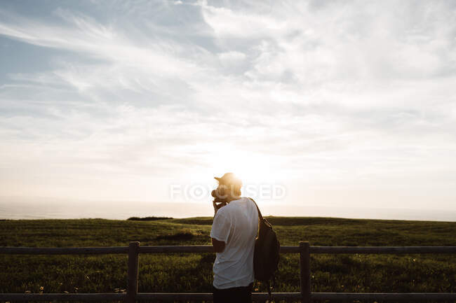 Tourist making photo of green forest on a road — Stock Photo