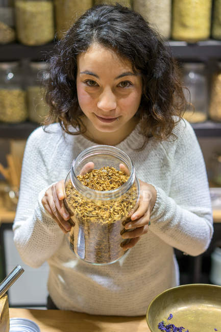 Close-up of Woman showing jar of spices in shop — Stock Photo