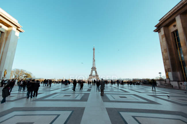 Unrecognizable people walking on big square at Eiffel tower in Paris, France. — Stock Photo