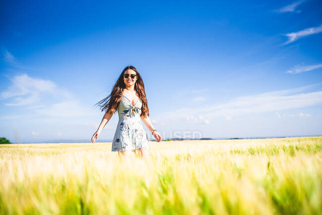 Дівчина стоїть в полі в сонячний день — стокове фото