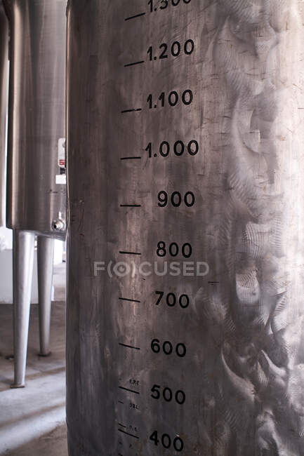 Instrumento de medição feito de metal com números na superfície em oficina de fábrica de licor — Fotografia de Stock
