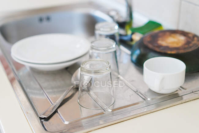 Lavado pratos e copos de secagem na pia na cozinha. — Fotografia de Stock