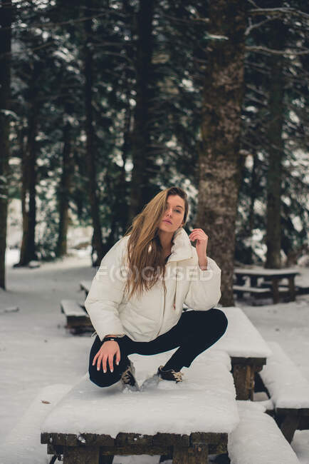 Young woman posing on table — Stock Photo